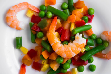 Shrimps with vegetables on a wooden table in rustic style