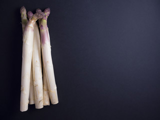 Bundle of fresh white asparagus isolated on dark background
