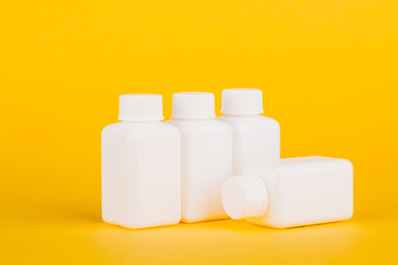 White medical bottles, on yellow background