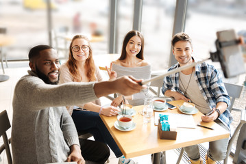 Bearded man taking selfies with friends