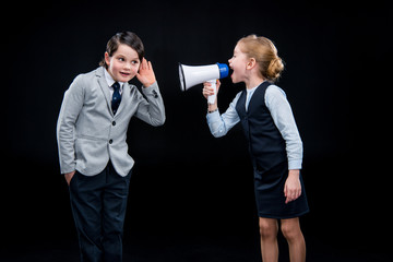 Girl with megaphone yelling on boy on black