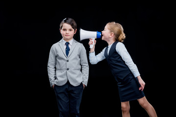 Girl with megaphone yelling on boy on black
