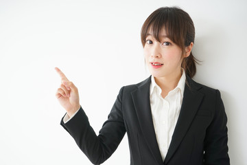 笑顔でポイントを示すスーツ姿の若いビジネスウーマン