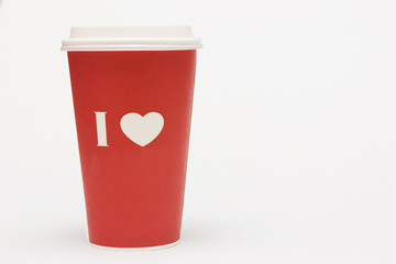 A red cup of coffee with love symbol on white background.