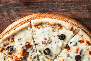 Traditional Italian food. Fresh yummy pizza on wooden rustic table with copy space for text, top view. Horizontal photo.