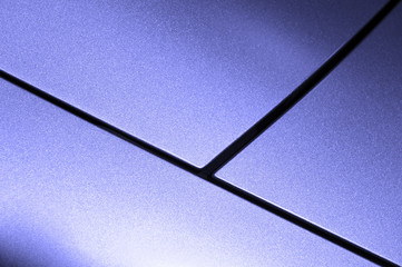 Surface of violet sport sedan car, detail of metal hood and fender of vehicle bodywork