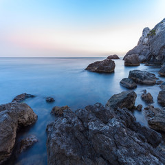 Obrazy na Plexi  Piękny pejzaż morski. Morze i skała o zachodzie słońca. Kompozycja natury. Fotografia z długim czasem naświetlania.