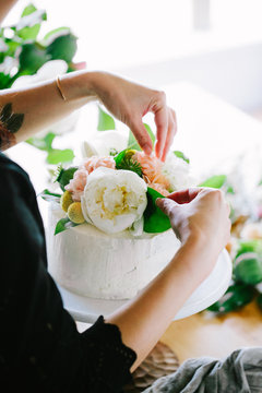 Decorating iced cake with flowers 