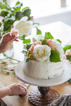 Decorating iced cake with flowers