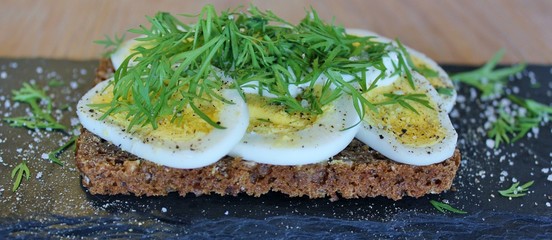 Traditional danish open sandwich with egg, sour cream, dill, salt and pepper
