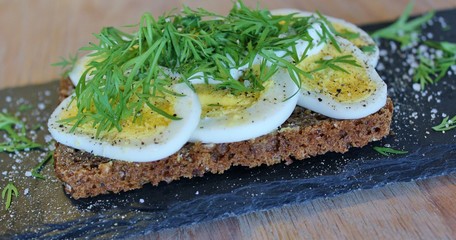 Traditional danish open sandwich with egg, sour cream, dill, salt and pepper
