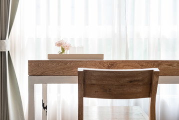 wooden desk beside white ruffle curtain