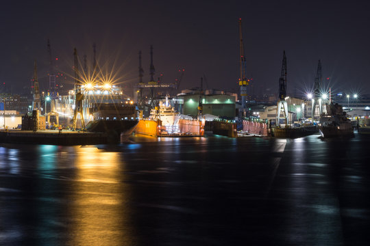 Shipyard Dockyard With Container Ships In Harbor Of Hamburg At Night