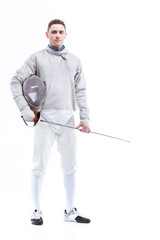 Young confident man professional fencer standing with helmet and rapier