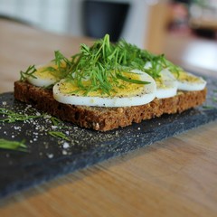 Traditional danish open sandwich with egg, sour cream, dill, salt and pepper
