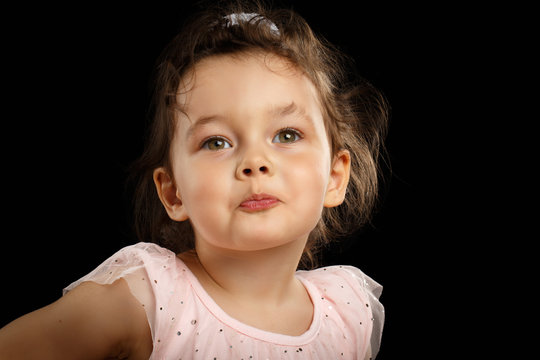 Close-up Portrait Of 3 Year Old Little Girl With Pink Dress, Send Kiss On Black Background