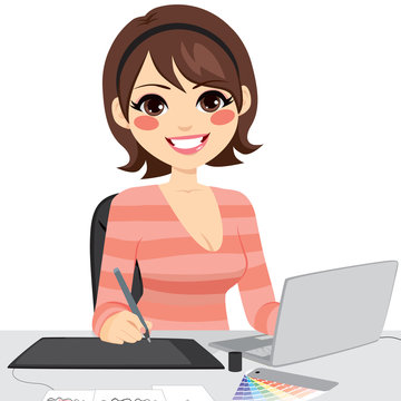 Beautiful female graphic designer working on laptop with graphic tabled and color chart