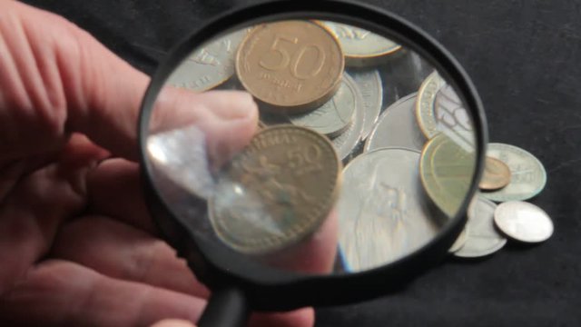 to see the collection of coins through a magnifying glass