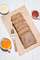 Close-up of slice of toast bread with jam and butter on wood table