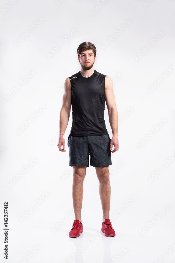 Sticker Handsome fitness man in black sleveless shirt, studio shot.