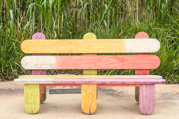 Wooden chair made from painted ice cream stick in park.