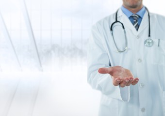 Doctor mid section with hand out against blurry window