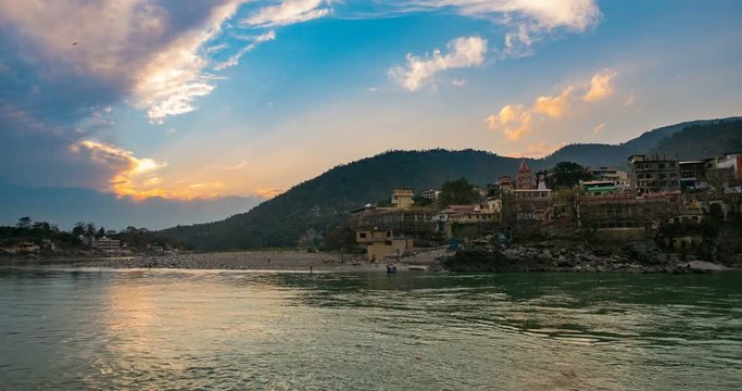 Dusk time lapse at Rishikesh, holy town and travel destination in India. Colorful sky and moving clouds over the Ganges River. 