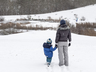 Fototapeta na wymiar Child and Mom outside snowy Day