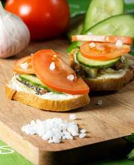 Sandwich with sprats,garlic,sauce,sea salt.cucumber and tomato