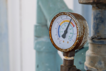 Closeup of manometer, measuring gas pressure. Pipes and valves at industrial plant.