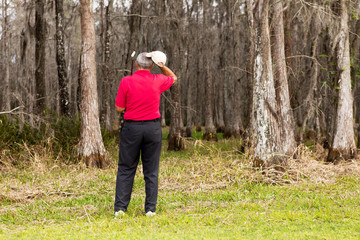 Senior man golfing in the rough