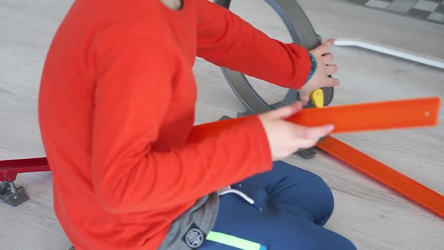 chłopczyk układa tor dla aut