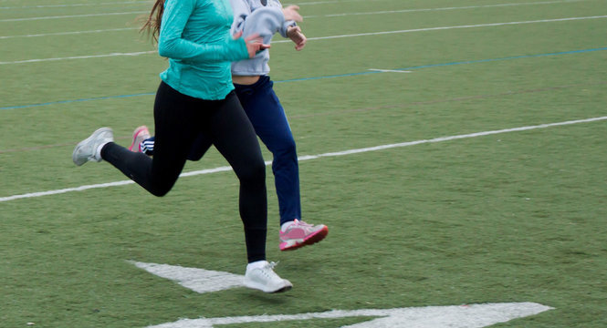 Teammates sprinting on a turf field