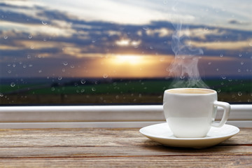 White cup of coffee on wooden windowsill