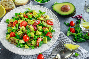 Quinoa tabbouleh salad with avocado, tomatoes, cucumber, green onion. Concept healthy food.