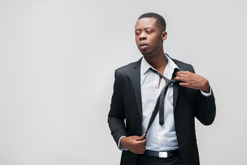 Afroamerican office employee. Tough work, hard breathing, problems, pressing staff, inability to rest. Grey background with free space.