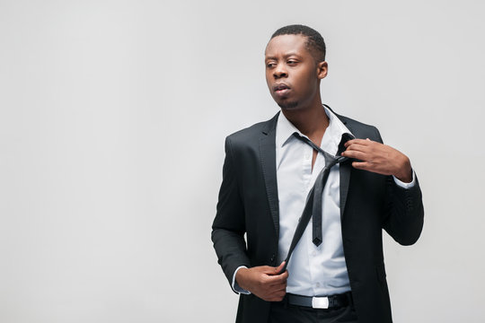 Afroamerican office employee. Tough work, hard breathing, problems, pressing staff, inability to rest. Grey background with free space.
