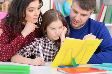 Parents helping daughter with lessons