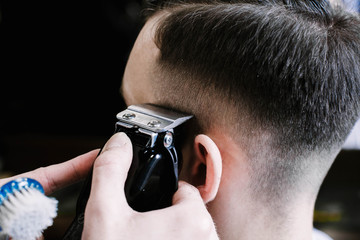 Barber cleans man's hair remained underneath the fade