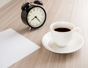 A cup of coffee and notebook on wood table . Coffee break in morning ,break working  / selective focus.Blank seating  indoor in living room .copy space for create idea for business.