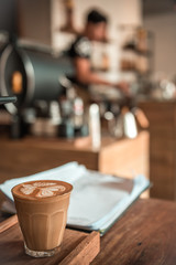 White cup of hot coffee on table in cafe. 