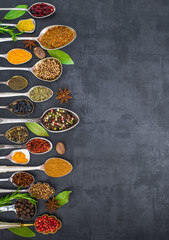 Various spices spoons on stone table. Top view .