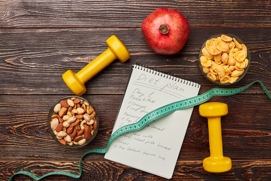 Dumbbells and notebook. Healthy food and sport tools. Get fit fast.