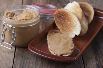 Toasts with peanut butter on a clay plate