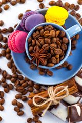 Cup of coffee and beans with delicious macaroon on a white background.