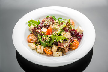 Healthy vegetarian salad and spicy soy cheese tofu with basil
