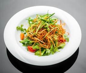 Vegetarian salad with fried potato chips and arugula on a plate