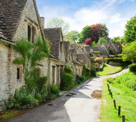 Fototapeta na wymiar A beautiful sunny morning in Bibury, Gloucestershir, England, UK. Old street with traditional cottages.