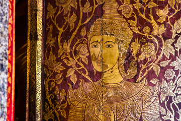 Golden antique drawing of Thai guarden angels on temple door