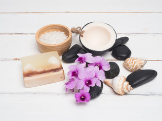 Obraz na płótnie Canvas Aromatherapy product Spa set ,candle ,soap,coconut orchid flower,shell, massage with white wood background . top view composition.